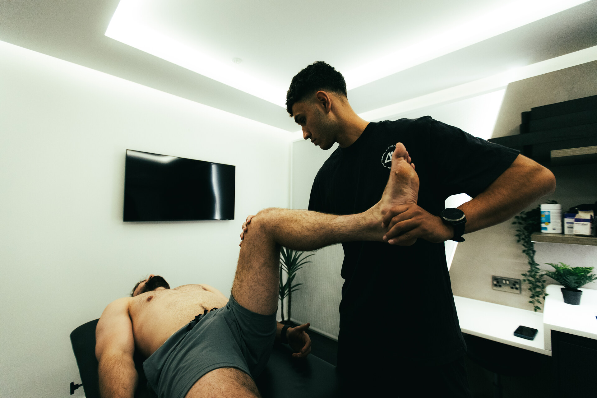 Coach assessing hip and leg mobility at DVOTION London