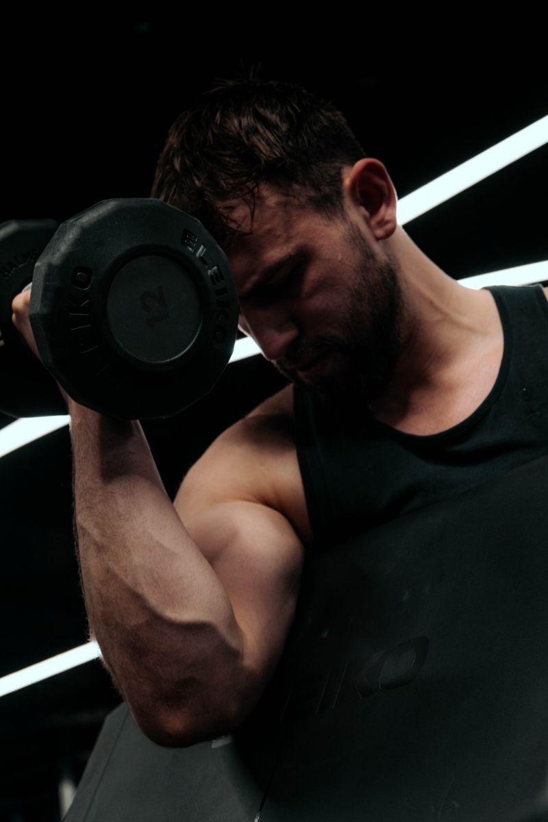 Rohan Forbes O'Neil, Performance Coach at DVOTION Labs, performing a dumbbell biceps curl